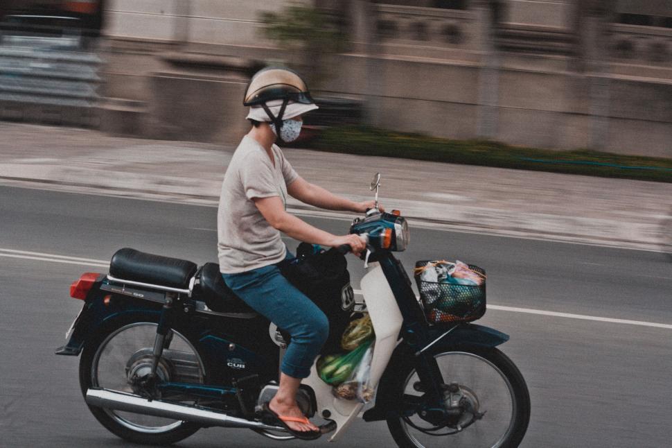 Free Image of Man Riding Motorcycle Down Street 