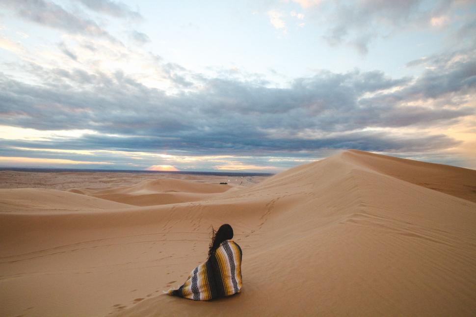 Free Image of Person Sitting in the Middle of a Desert 
