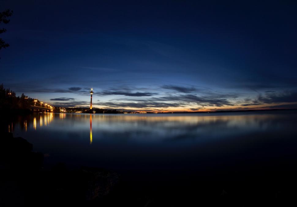 Free Image of Nighttime View of a Lighthouse Across a Body of Water 