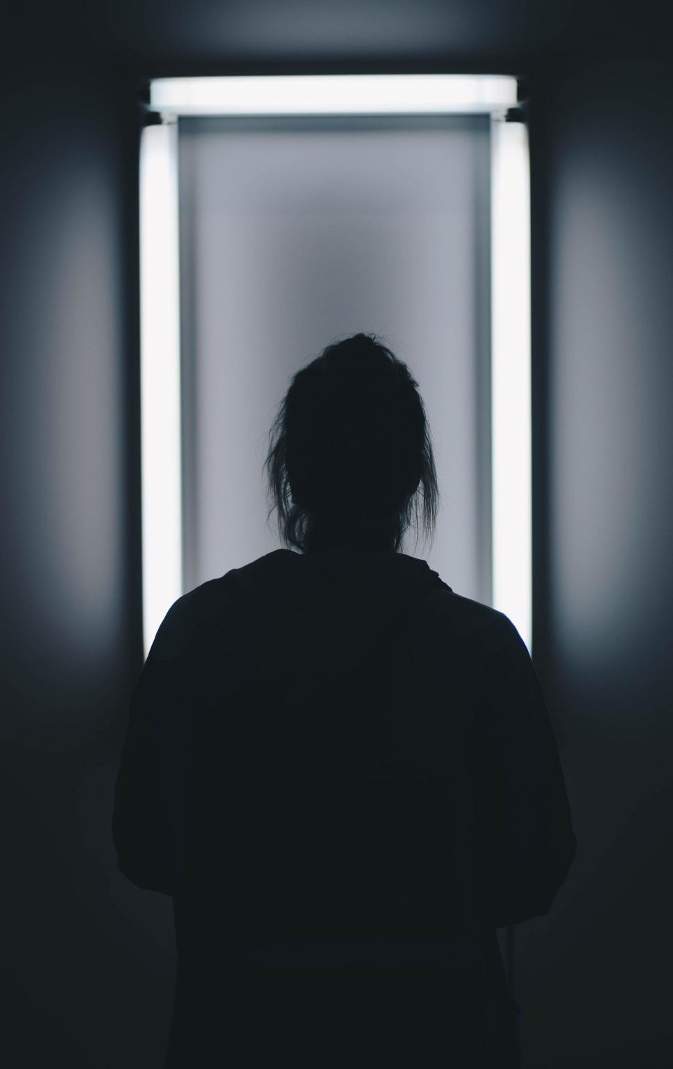 Free Image of Person Standing in Front of Mirror in Dark Room 