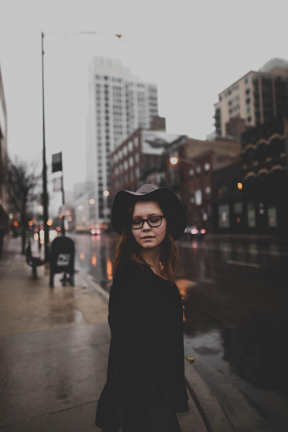 Free Image of Woman Standing on Sidewalk in Rain 