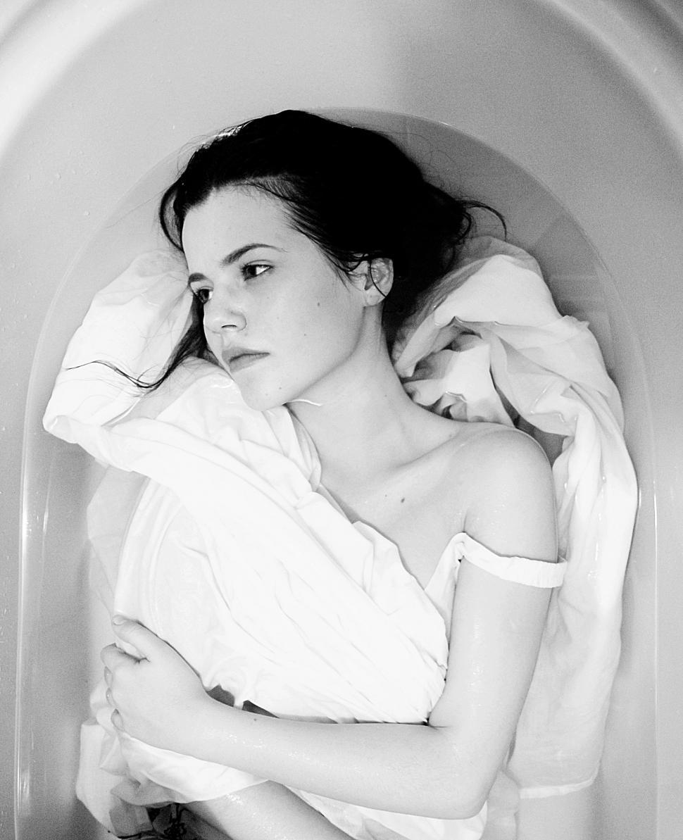 Free Image of Woman Laying in Bathtub Covered in Blanket 