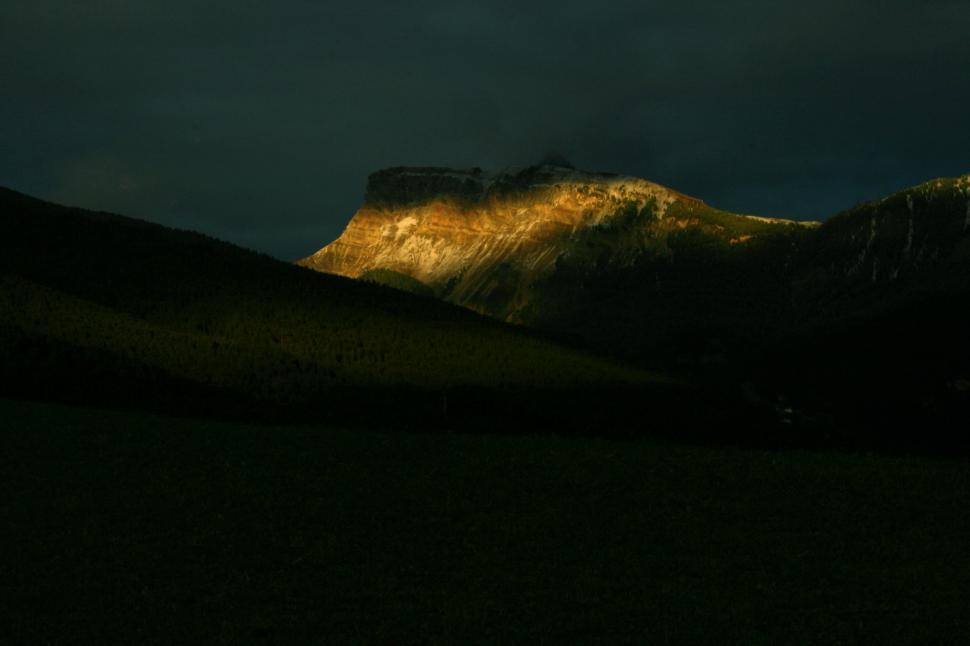 Free Image of Sun Shining on Mountains in the Dark 