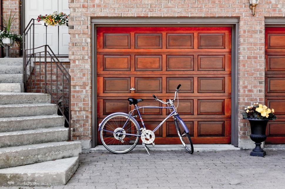 Free Image of Bicycle Parked in Front of Garage Door 
