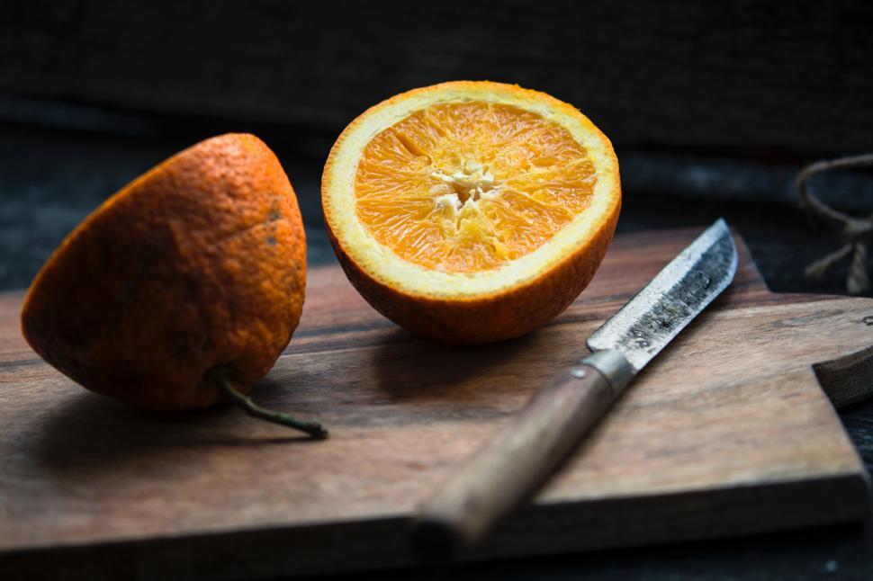 Free Image of Orange Halves on Cutting Board With Knife 