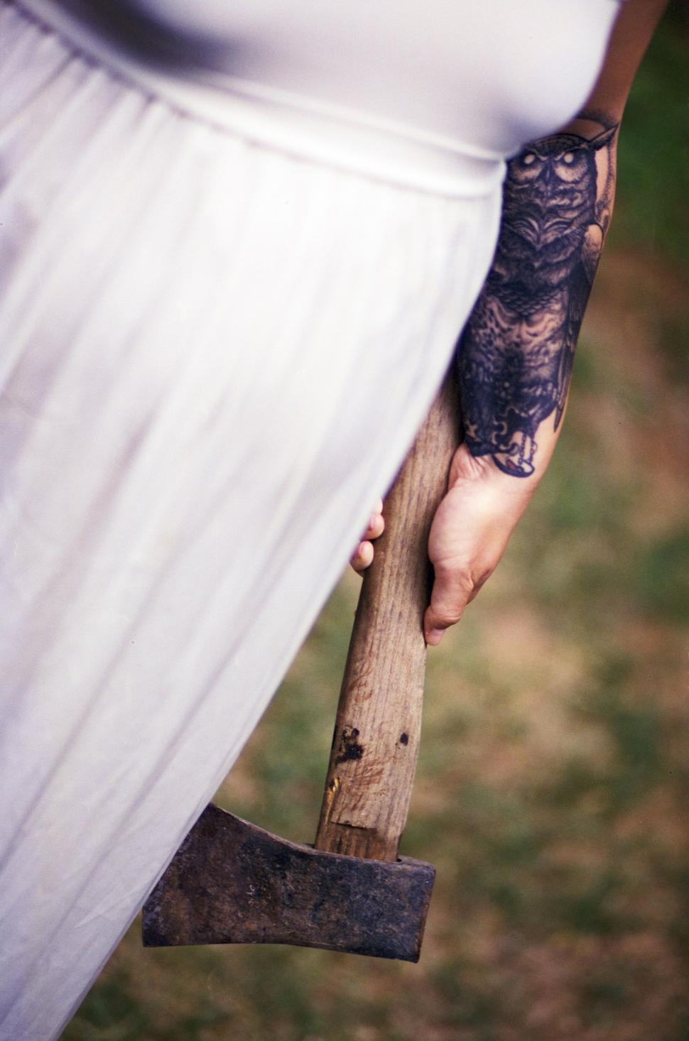 Free Image of Woman in White Dress Holding Large Axe 