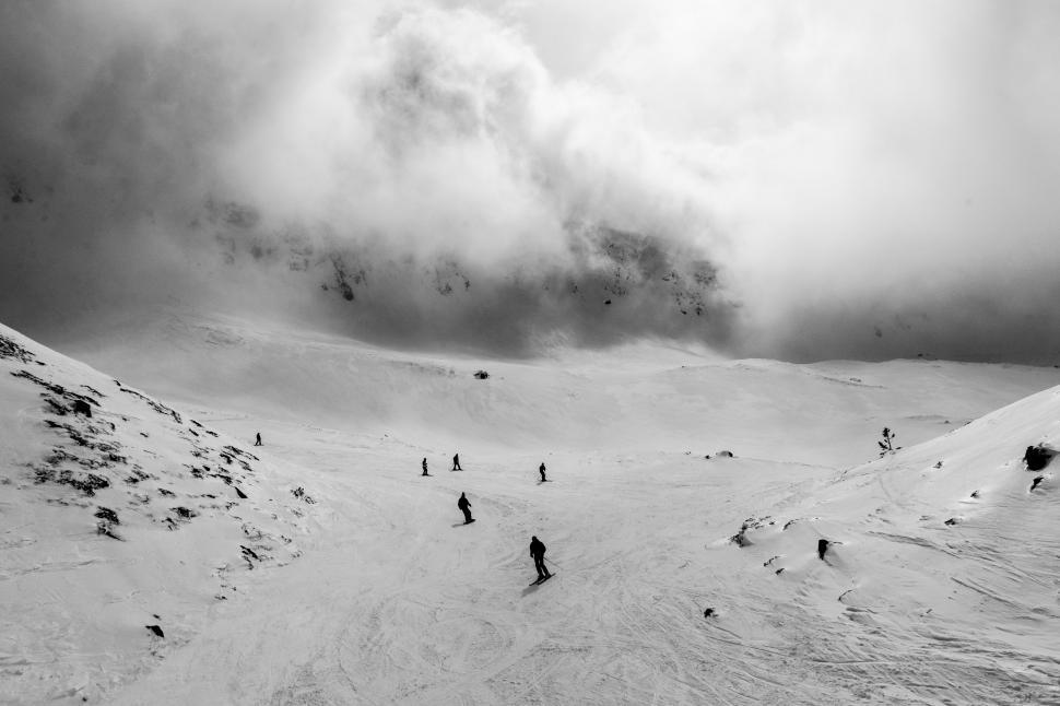 Free Image of Group of People Skiing Down Snow Covered Slope 