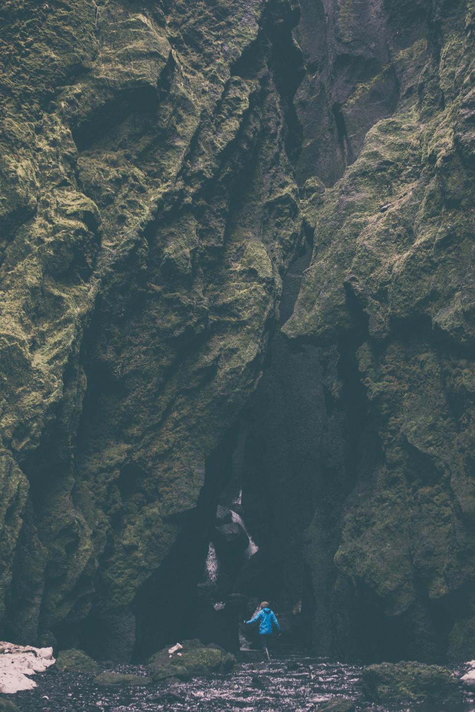 Free Image of Person Standing in Front of Cave 