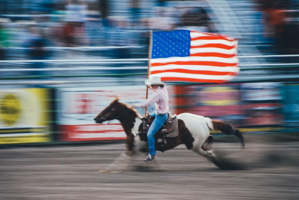 Free Image of Person Riding Horse Holding Flag 