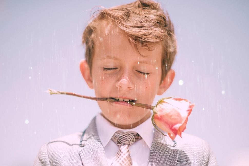Free Image of Young Boy Wearing Suit and Tie With Straw in Mouth 