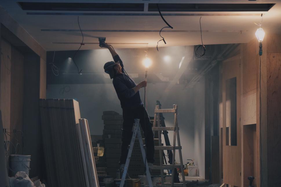 Free Image of Man Standing on Ladder in Room 