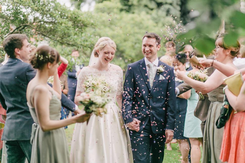 Free Image of Bride and Groom Walking Through Confetti 