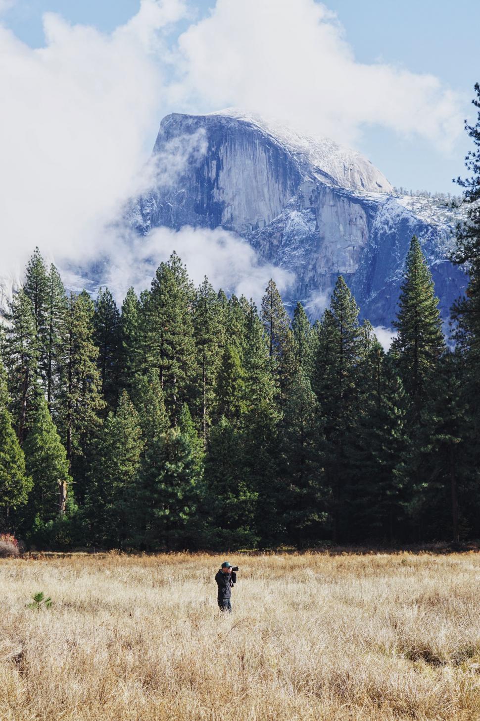 Free Image of Two People Standing in Field With Mountain Background 