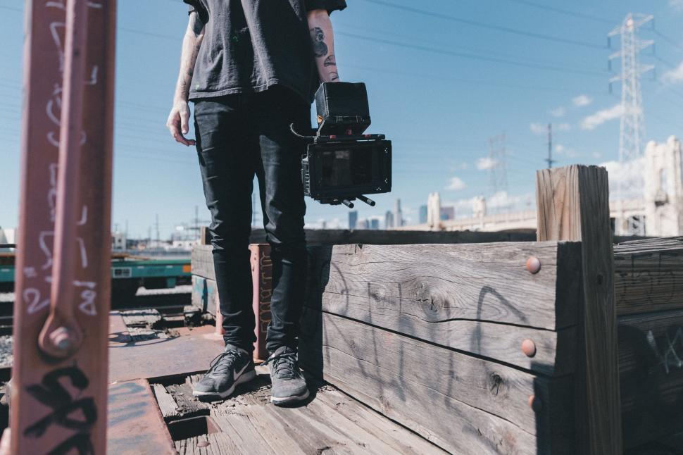 Free Image of Man Standing on Wooden Platform With Camera 