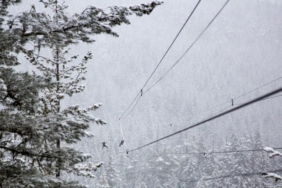 Free Image of Person Riding a Ski Lift on a Snowy Day 