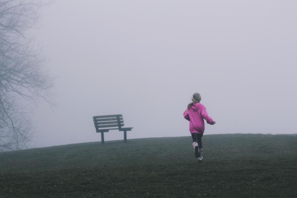 Free Image of Person Running in Foggy Field Near Bench 