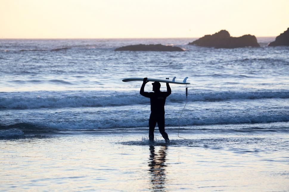 Free Image of Man Holding Surfboard on Beach 