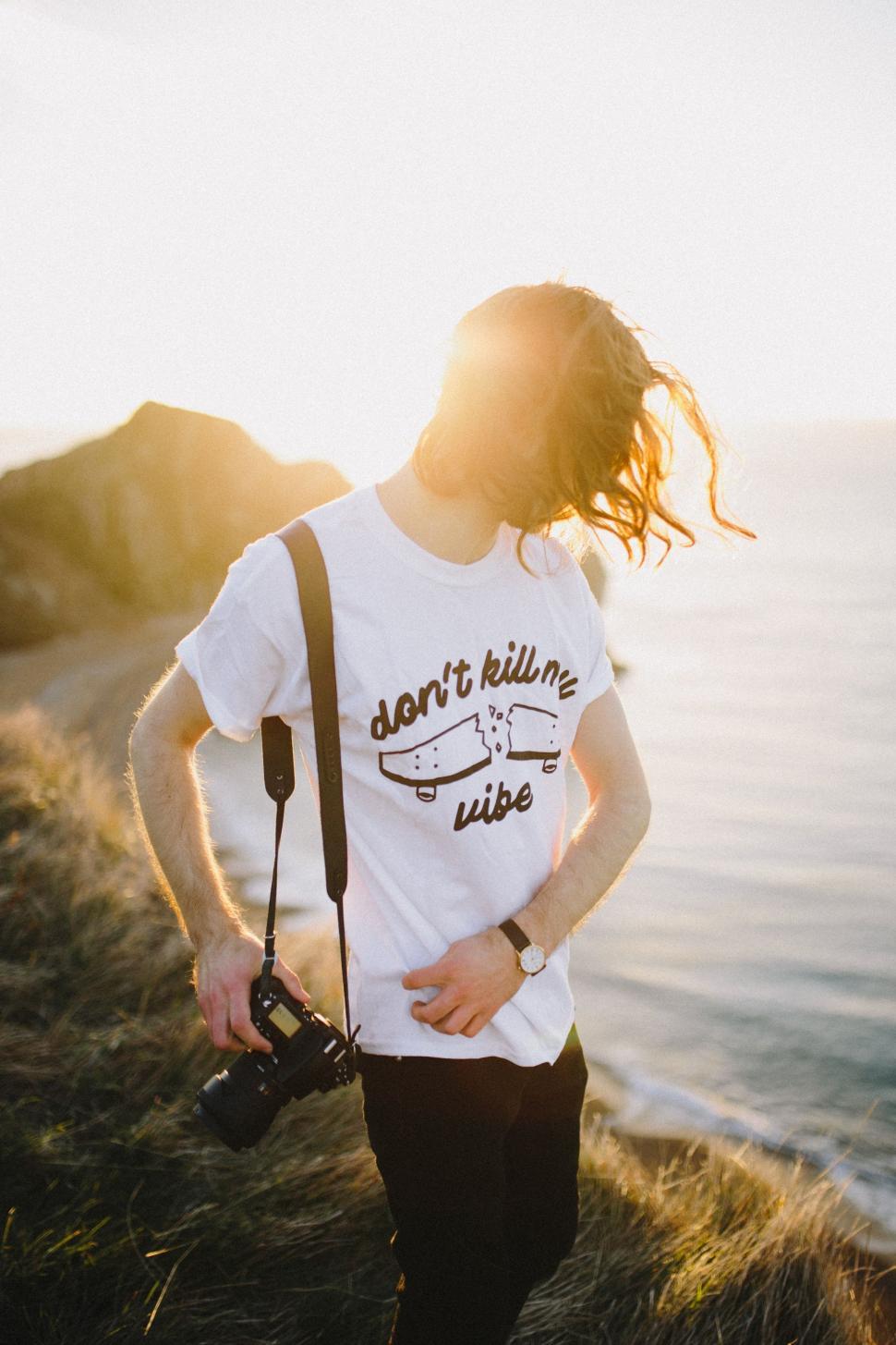 Free Image of Man With Dreadlocks Standing on Hill Next to Ocean 