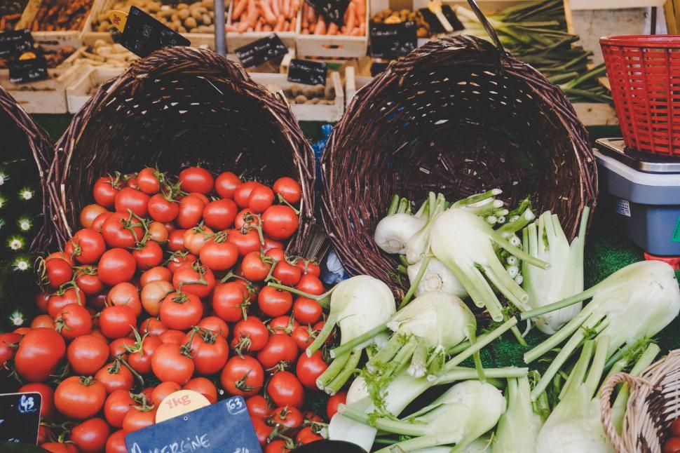 Free Image of Baskets of Tomatoes, Onions, and Other Vegetables on Display 