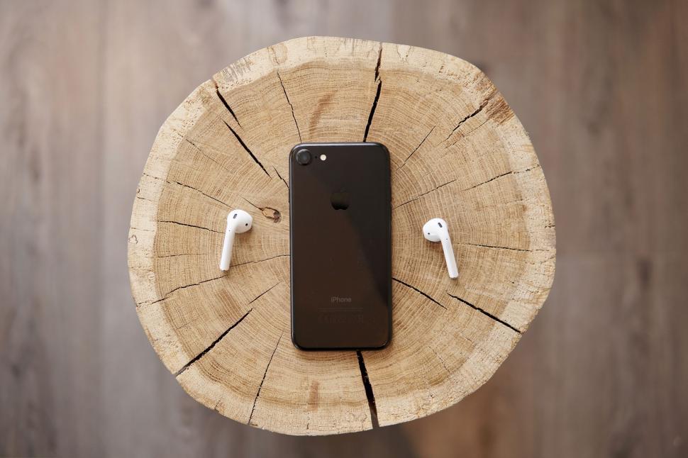 Free Image of Iphone and Ear Buds on Piece of Wood 