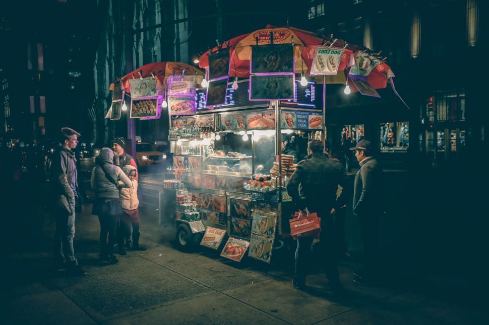 Free Image of Group of People Standing Around a Food Cart 
