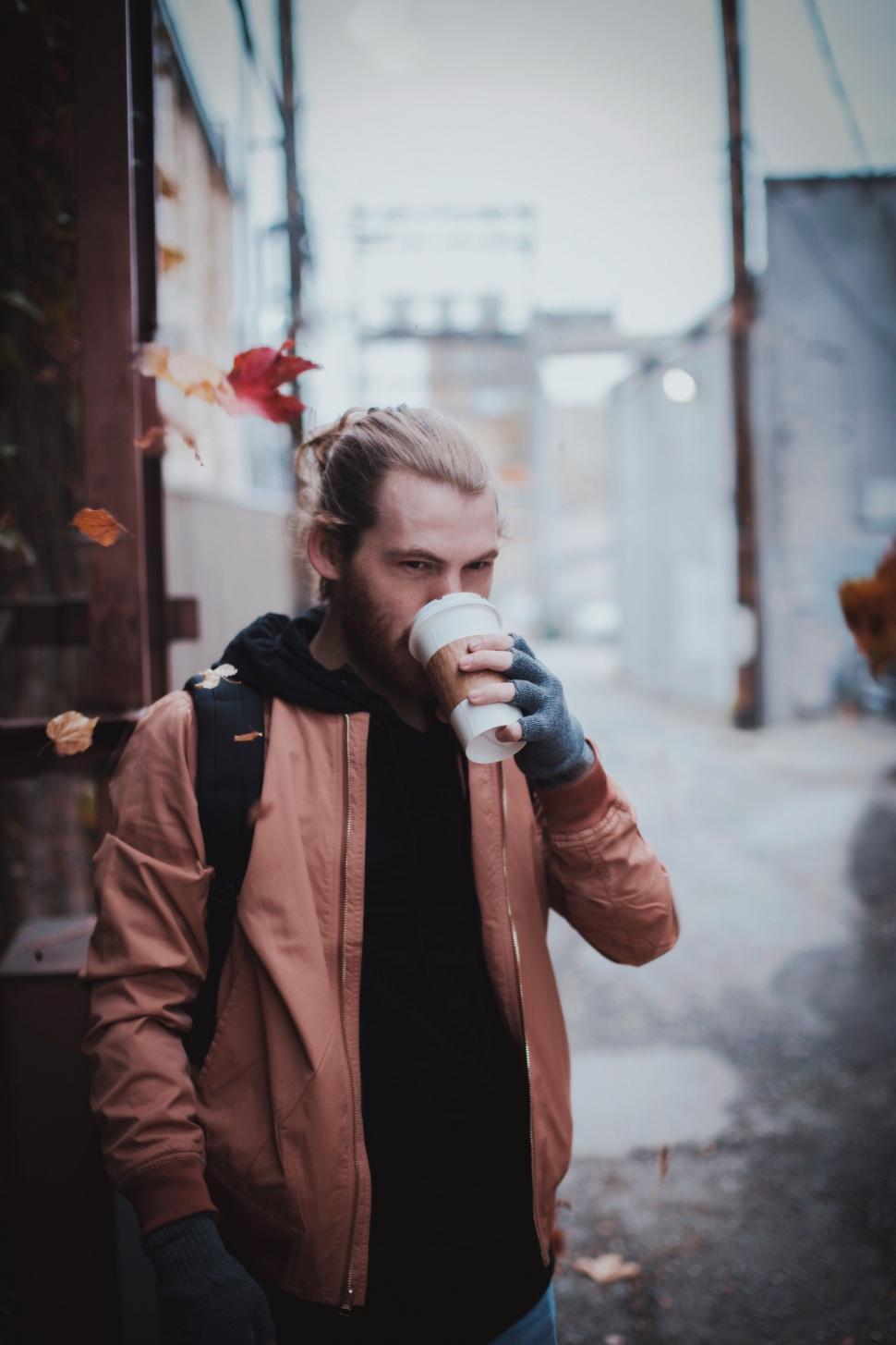 Free Image of Man Standing on Street Holding a Cup of Coffee 