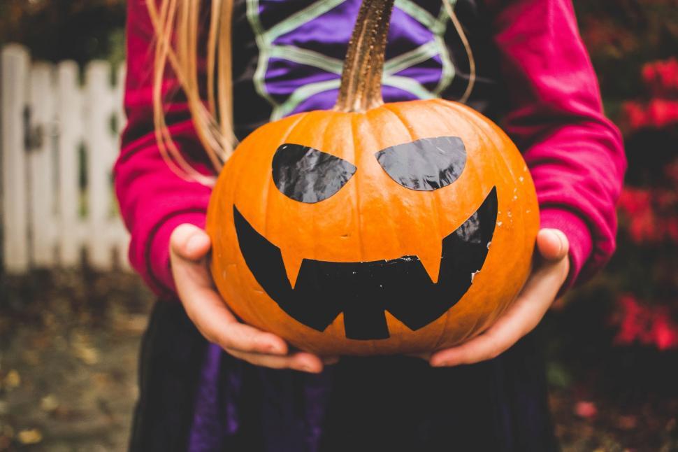 Free Image of Person Holding Pumpkin With Scary Face 