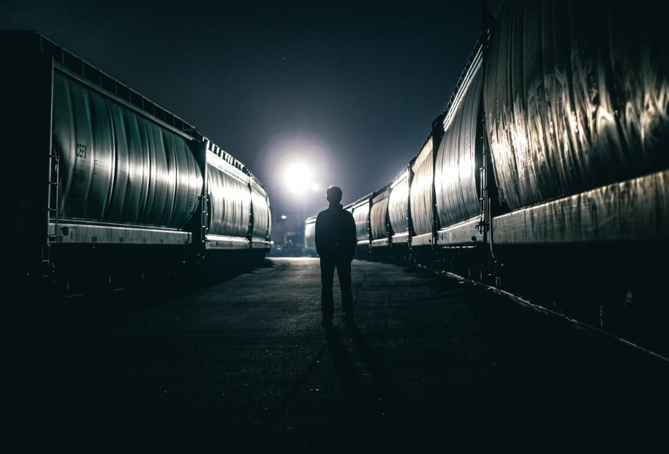 Free Image of Man Standing in Front of Row of Train Cars 