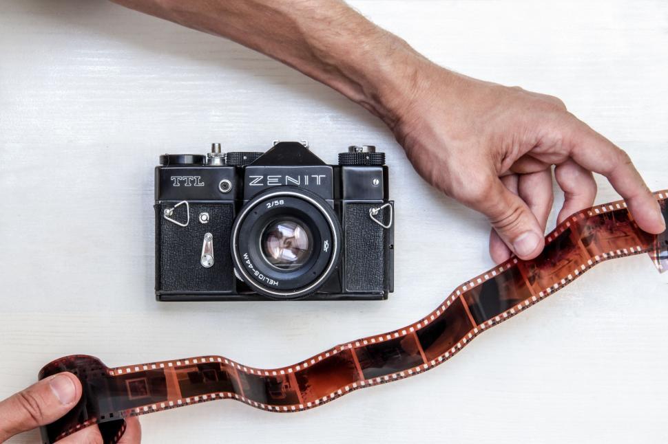 Free Image of Person Holding Camera Next to Film Strip 