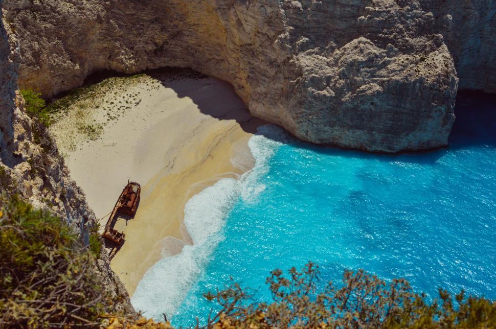 Free Image of Car Parked on Beach Next to Cliff 