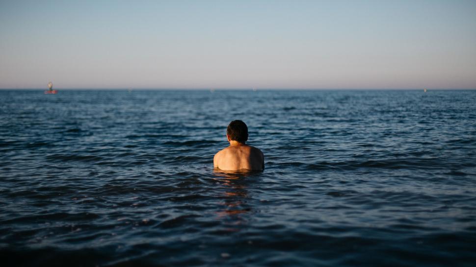 Free Image of Man Standing in Middle of Body of Water 