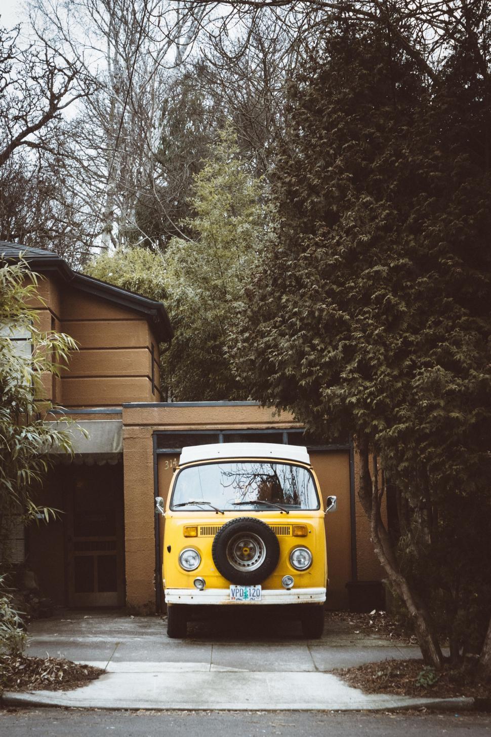 Free Image of Yellow and White Van Parked in Front of House 