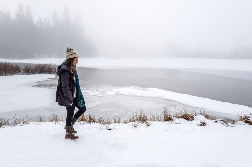 Free Image of Person Standing in Snow Near Body of Water 