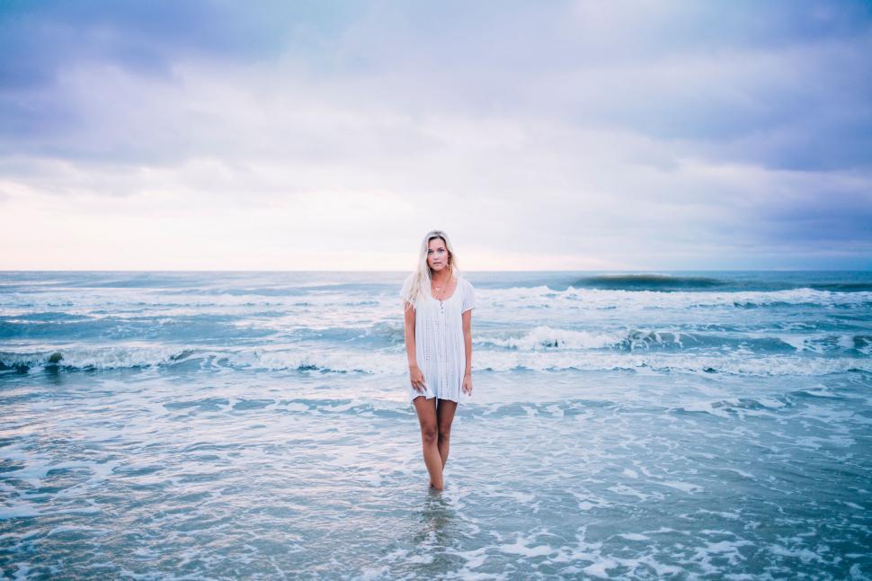 Free Image of Woman in White Dress Standing in Ocean 