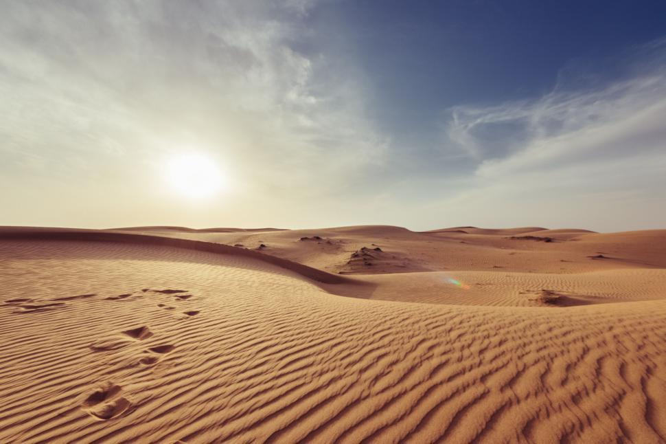 Free Image of Footprints in the Sand of a Desert Under a Blue Sky 