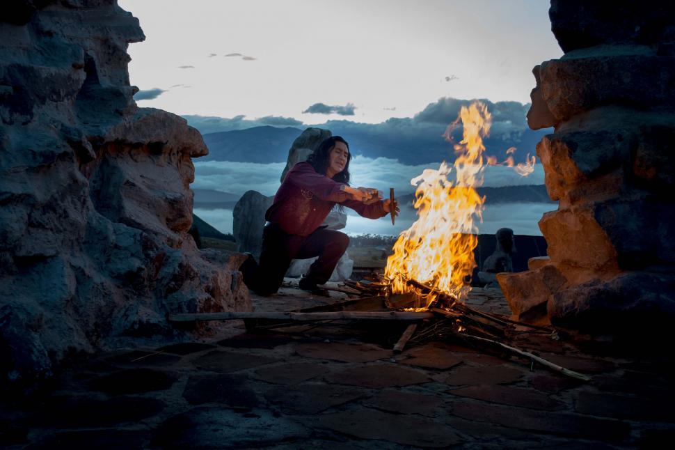 Free Image of Man Sitting by Fire in Cave 