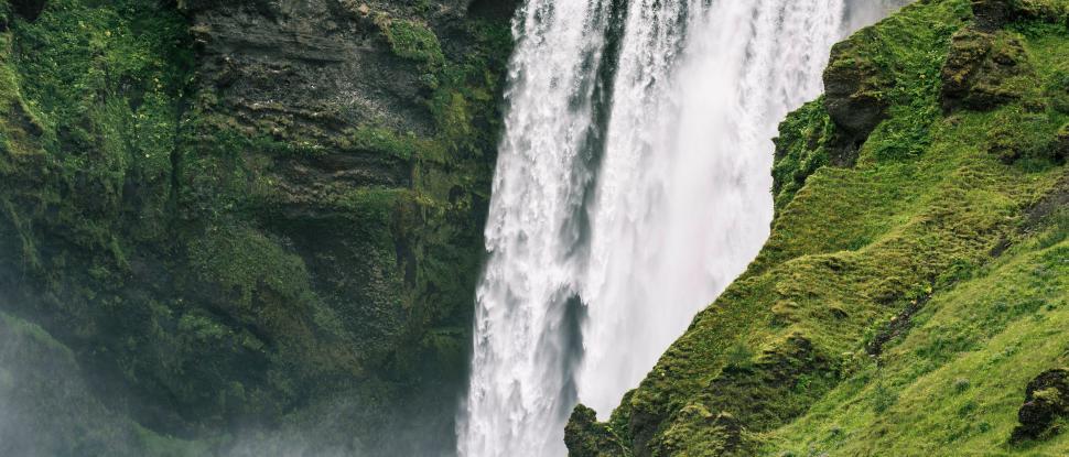 Free Image of Man Standing in Front of Waterfall 