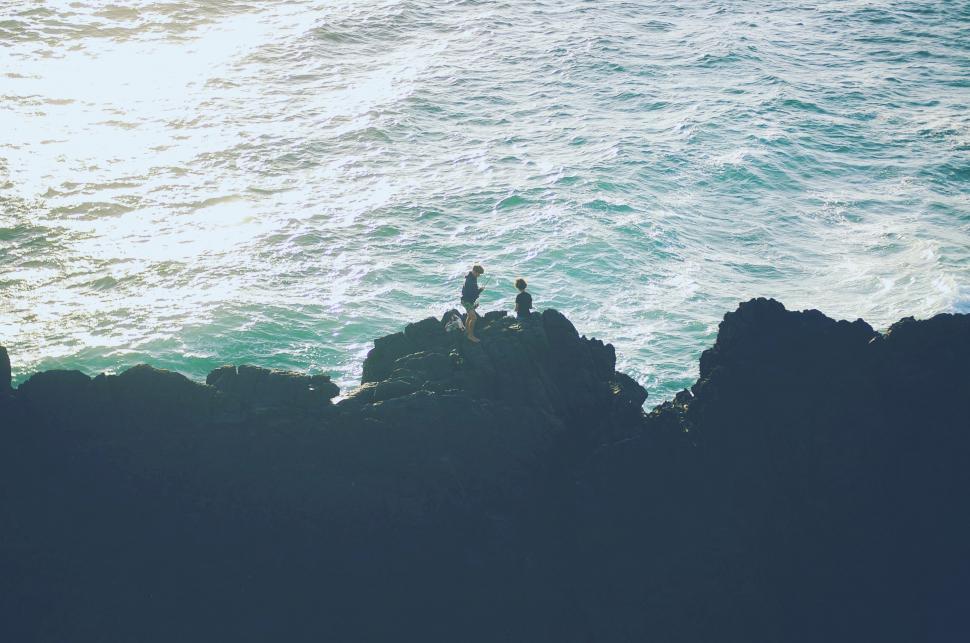 Free Image of Couple Standing on Cliff by Ocean 