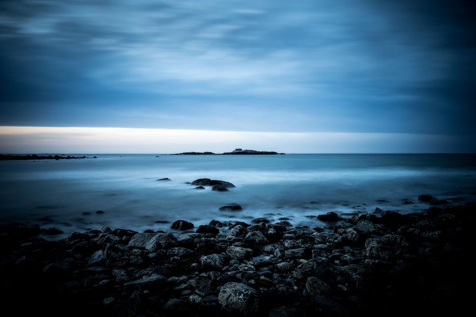 Free Image of Dark Blue Ocean With Rocks Under Cloudy Sky 