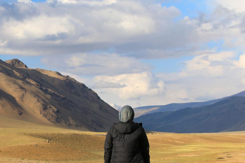 Free Image of Person Standing in Field With Mountains Background 