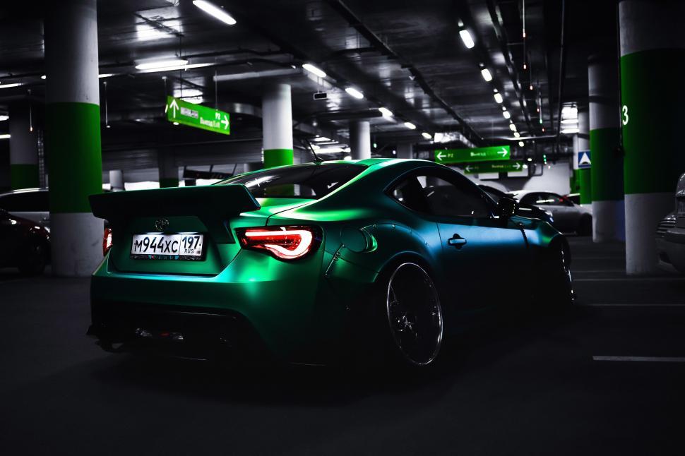 Free Image of Green Sports Car Parked in a Parking Garage 