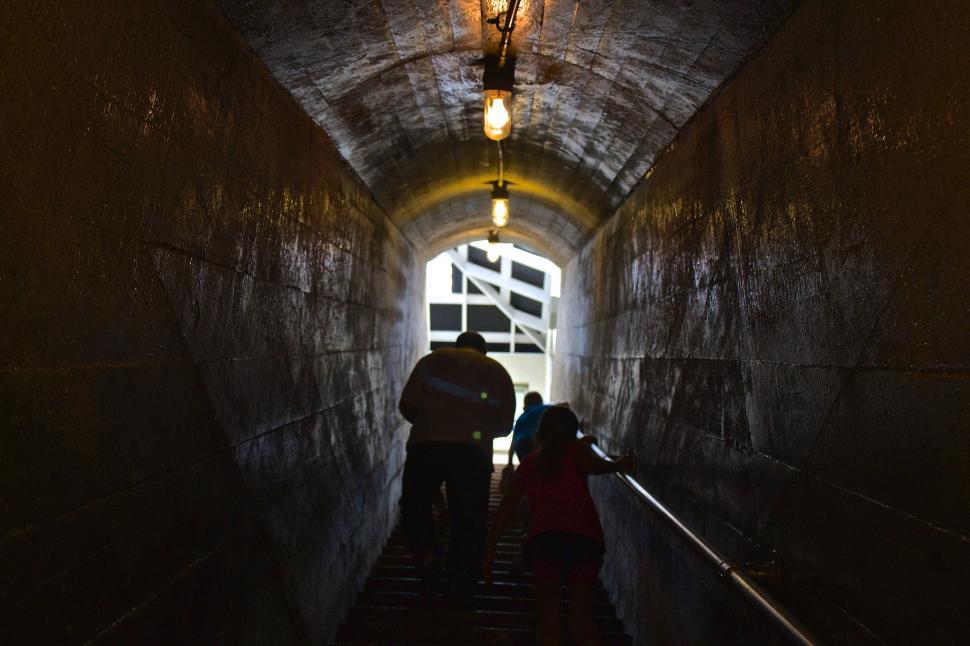 Free Image of Man and Woman Walking Down Dark Tunnel 