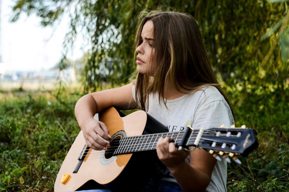 Free Image of Woman Playing Guitar in Grass 