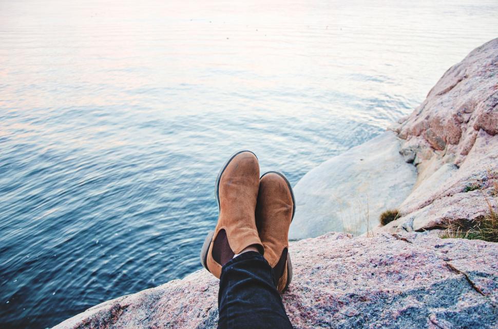 Free Image of Person Resting With Feet Up on Rock by Water 