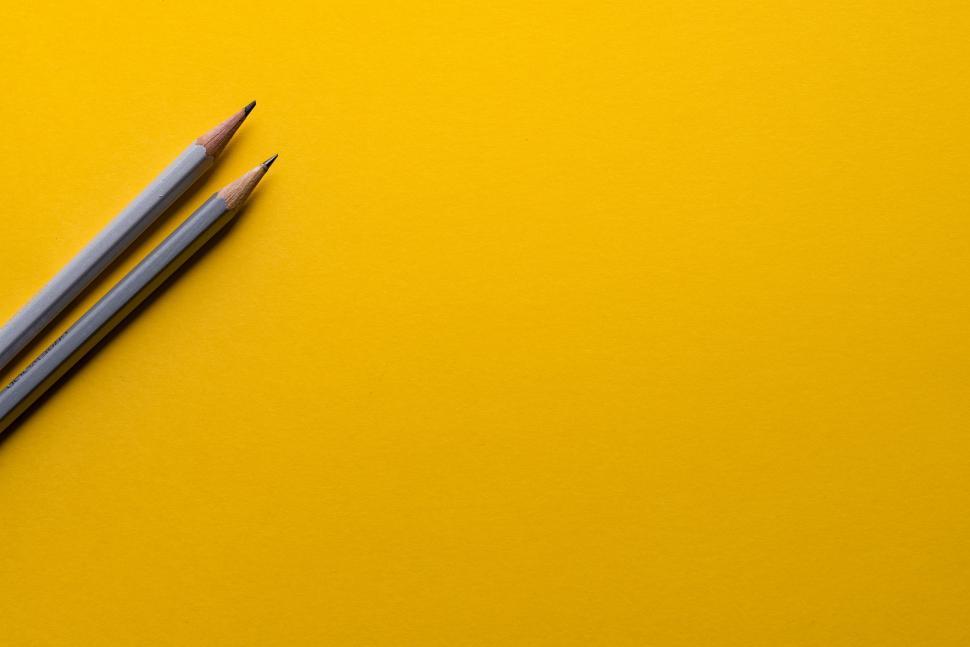 Free Image of Two Pencils on Yellow Surface 
