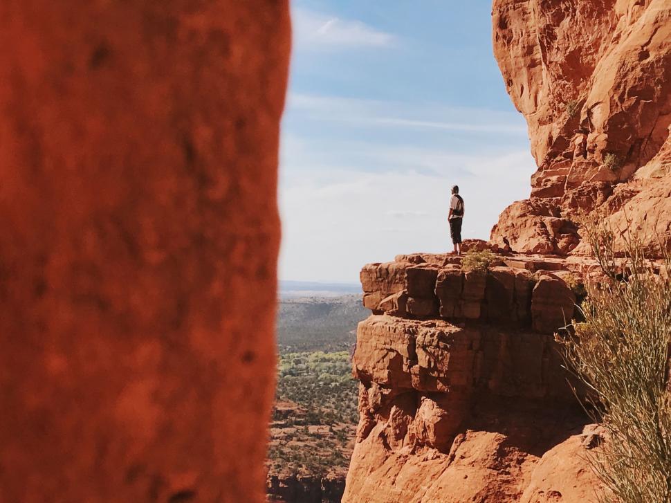 Free Image of Person Standing on Top of Rock Formation 
