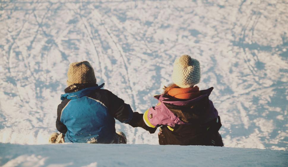Free Image of Couple Sitting on Snow Covered Slope 