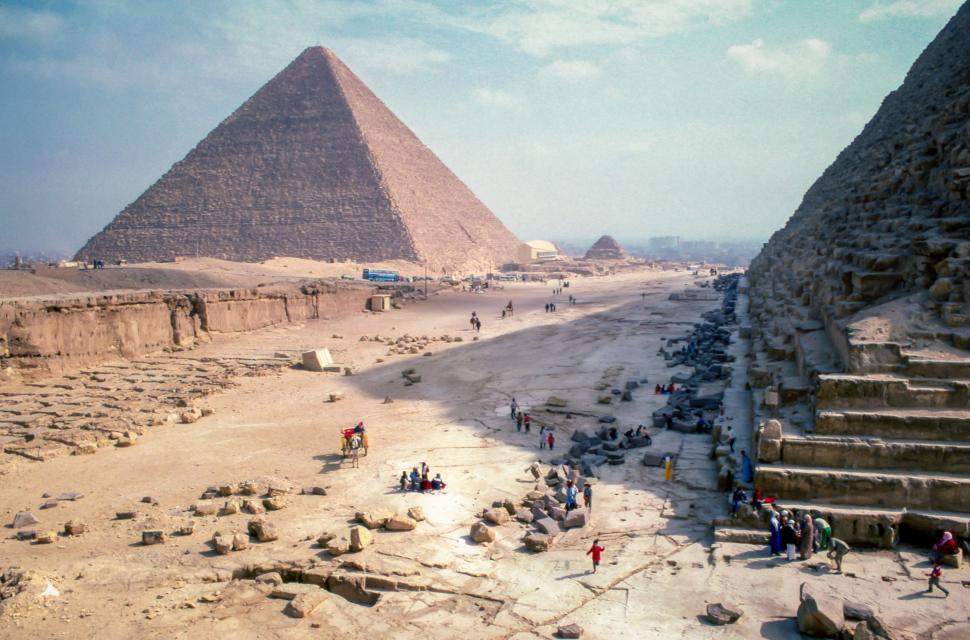 Free Image of Group of People Standing in Front of Two Pyramids 