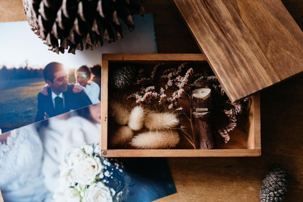 Free Image of Wooden Box Filled With Photos and Pine Cone 