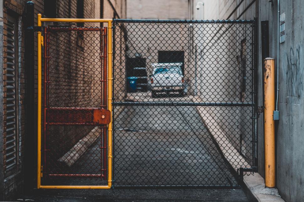 Free Image of Gated Entrance to Building With Truck in Background 
